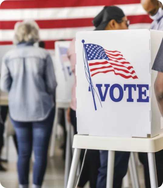 Several people gathered around an American voting box