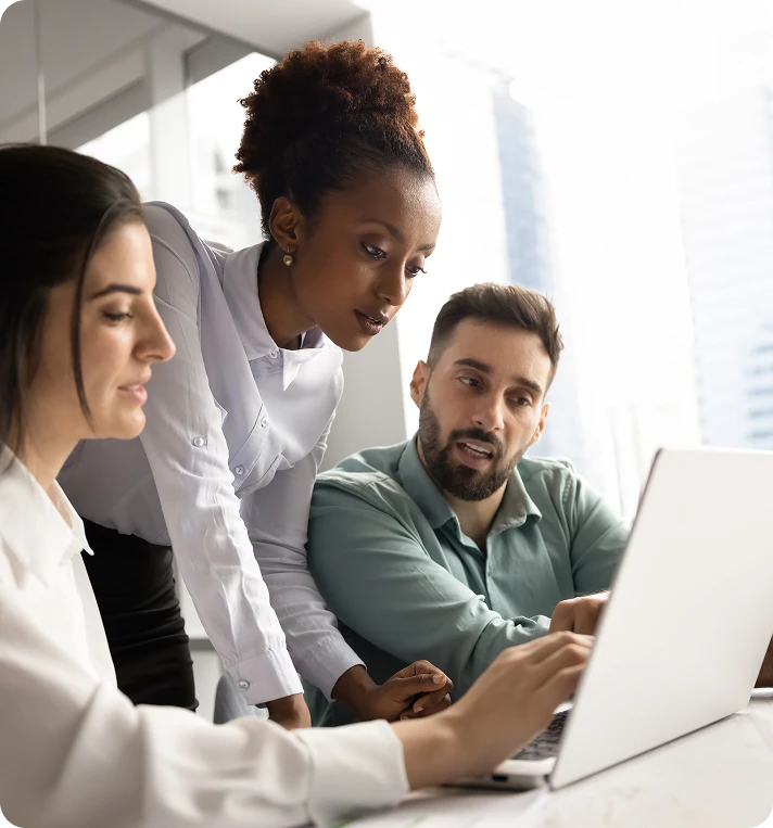 Three people reading off a laptop